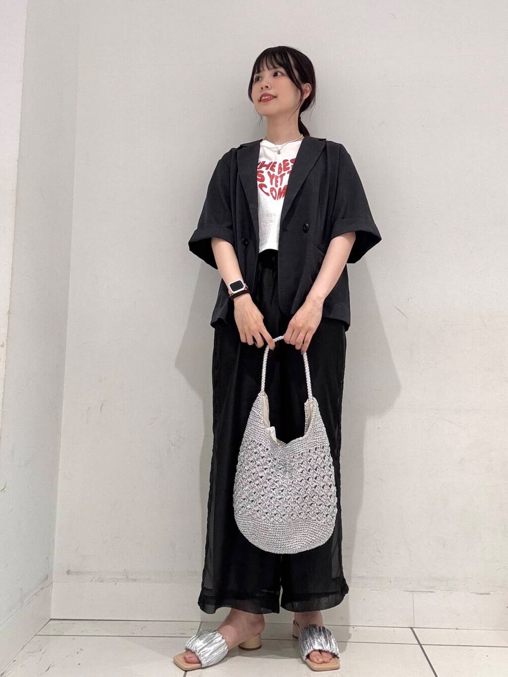 シルバー系のハンドバッグ、シルバー系のサンダル、グレー系のその他アウターを着用したレディースの春コーディネートの4枚目の写真