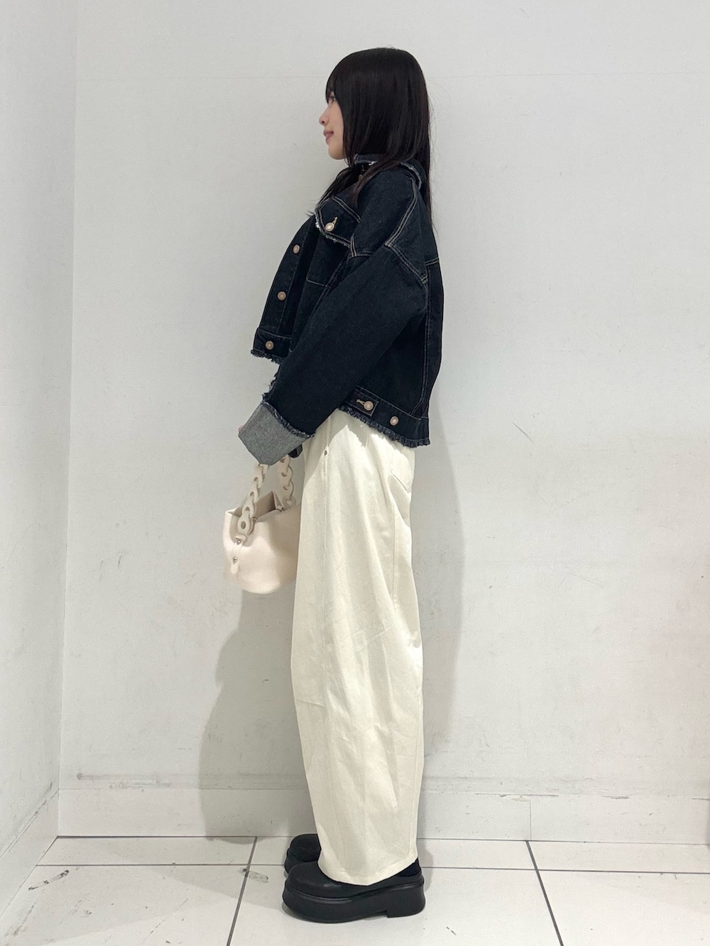 ピンク系のTシャツ/カットソー、ブルー系のデニムジャケット、ホワイト系のショルダーバッグを着用したレディースの冬コーディネートの2枚目の写真