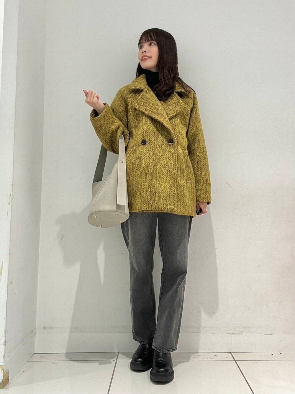 ブラック系のニット/セーター、グレー系のその他パンツ、ベージュ系のハンドバッグを着用したレディースの秋コーディネートの3枚目の写真