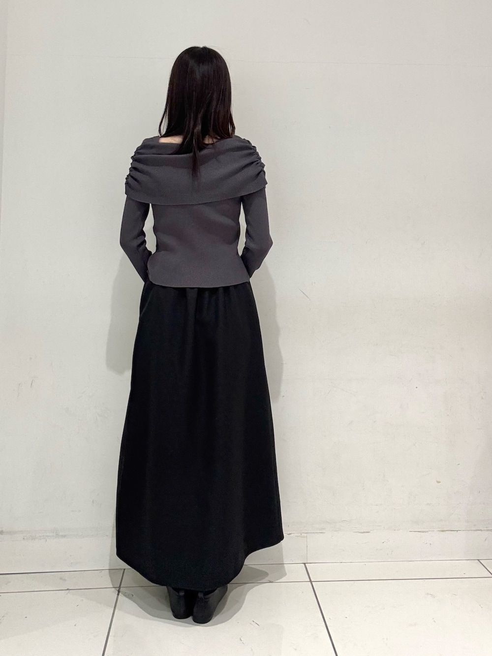 グレー系のニット/セーター、ブラック系のスカート、ブラック系のその他シューズを着用したレディースの冬コーディネートの3枚目の写真