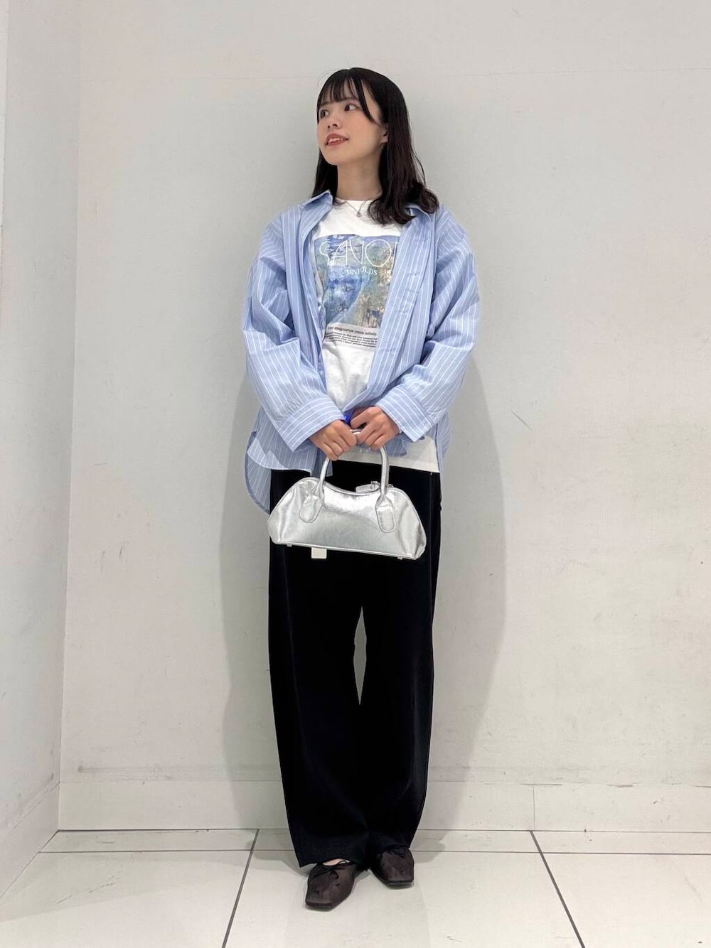 ブラック系のバレエシューズ、シルバー系のボストンバッグ、ブルー系のシャツ/ブラウスを着用したレディースの冬コーディネートの4枚目の写真