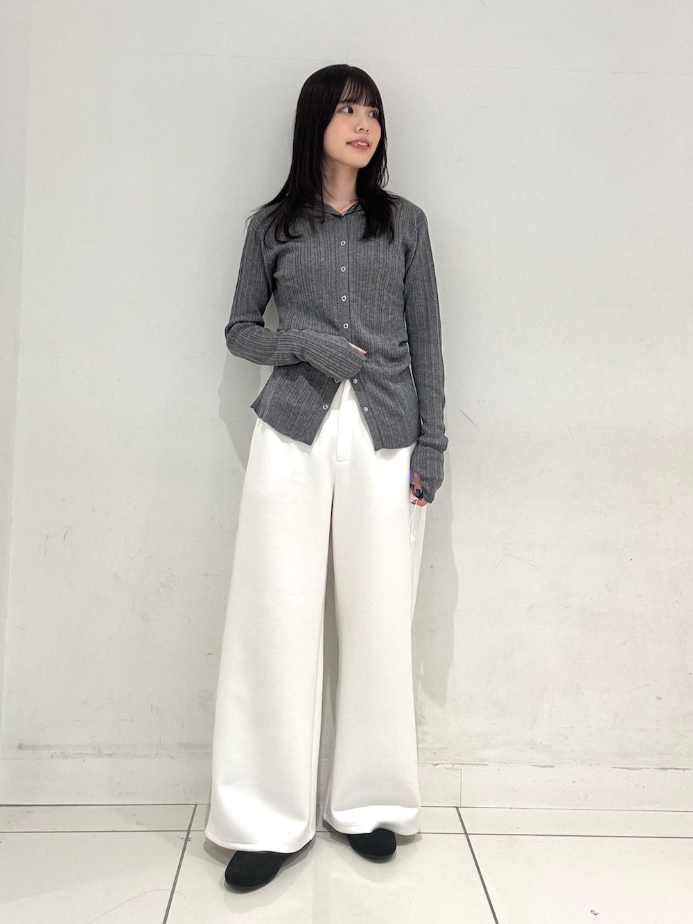 ブラック系のテーラードジャケット、グレー系のニット/セーター、ホワイト系のその他パンツを着用したレディースの春コーディネートの5枚目の写真