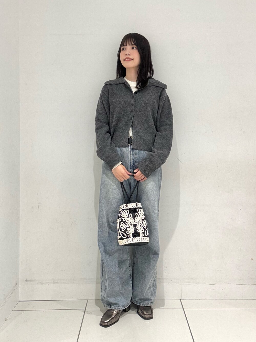 グレー系のニット/セーター、ホワイト系のニット/セーター、ブルー系のデニムパンツを着用したレディースの秋コーディネートの4枚目の写真