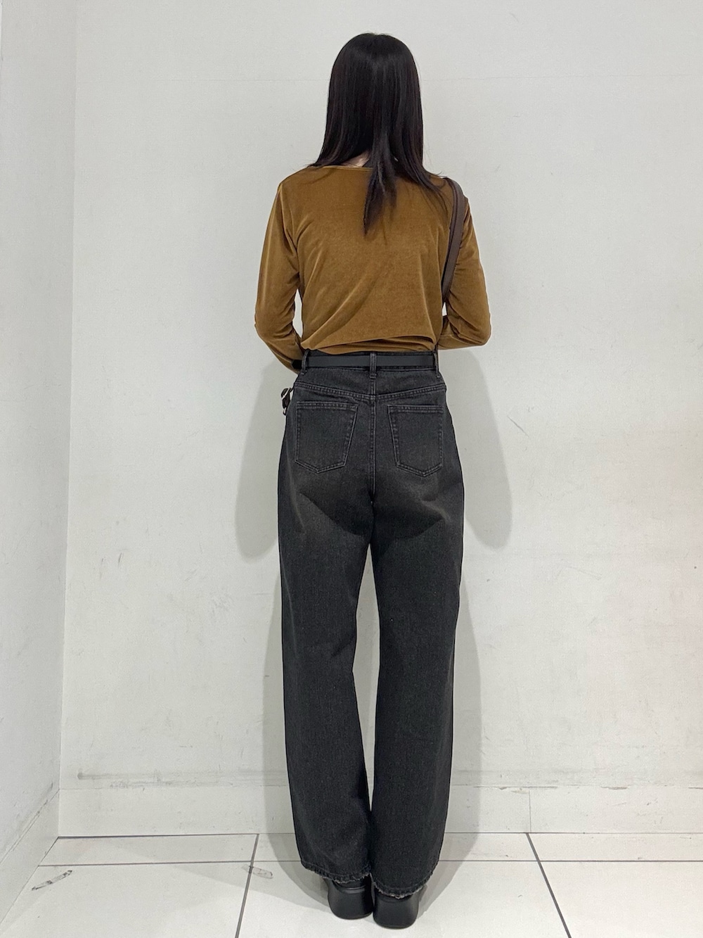 イエロー系のその他トップス、ブラック系のデニムパンツ、ブラウン系のバックパック/リュックを着用したレディースの冬コーディネートの3枚目の写真