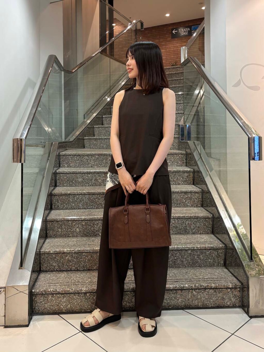 ブラウン系のボストンバッグ、ベージュ系のタンクトップ、ブラウン系のセットアップを着用したレディースの春コーディネートの4枚目の写真