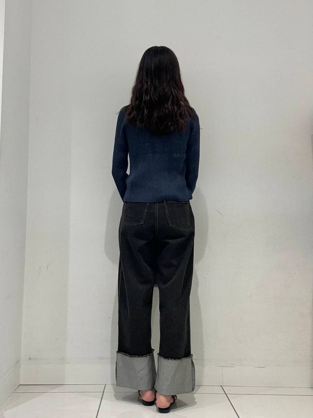 ブルー系のパンプス、グレー系のトートバッグ、ブルー系のニット/セーターを着用したレディースの夏コーディネートの2枚目の写真