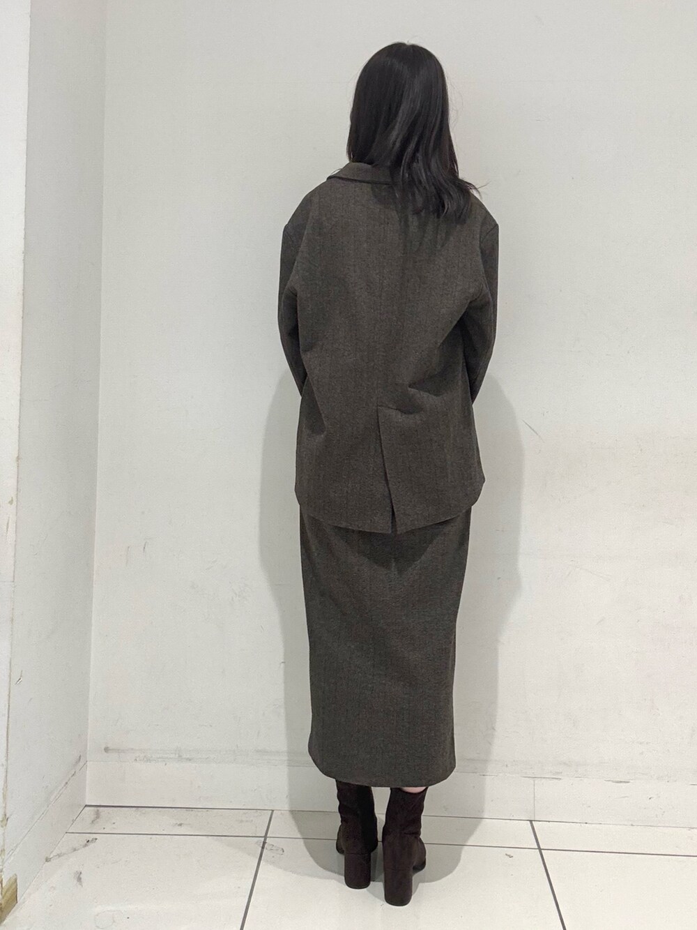 ブラウン系のその他アウター、ブラウン系のブーツ、ブラウン系のスカートを着用したレディースの秋コーディネートの3枚目の写真