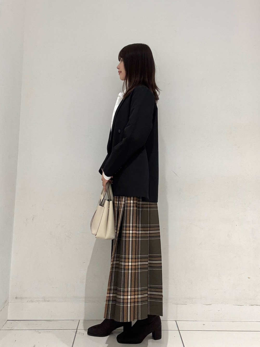 ブラック系のその他アウター、ホワイト系のシャツ/ブラウス、ブラウン系のスカートを着用したレディースの秋コーディネートの2枚目の写真