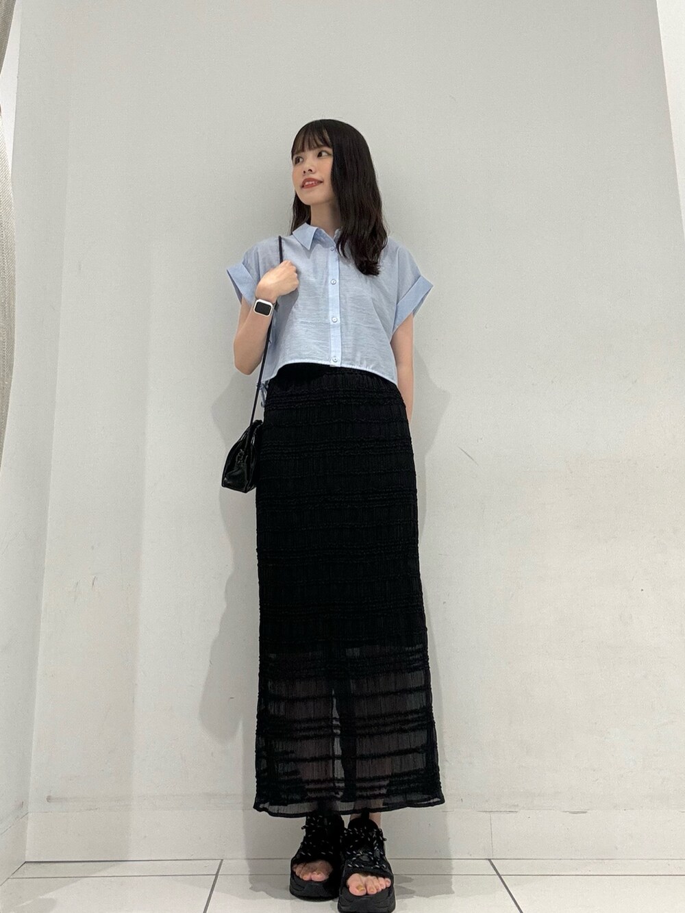 ブルー系のシャツ/ブラウス、ブラック系のスカート、ブラック系のショルダーバッグを着用したレディースの夏コーディネートの2枚目の写真