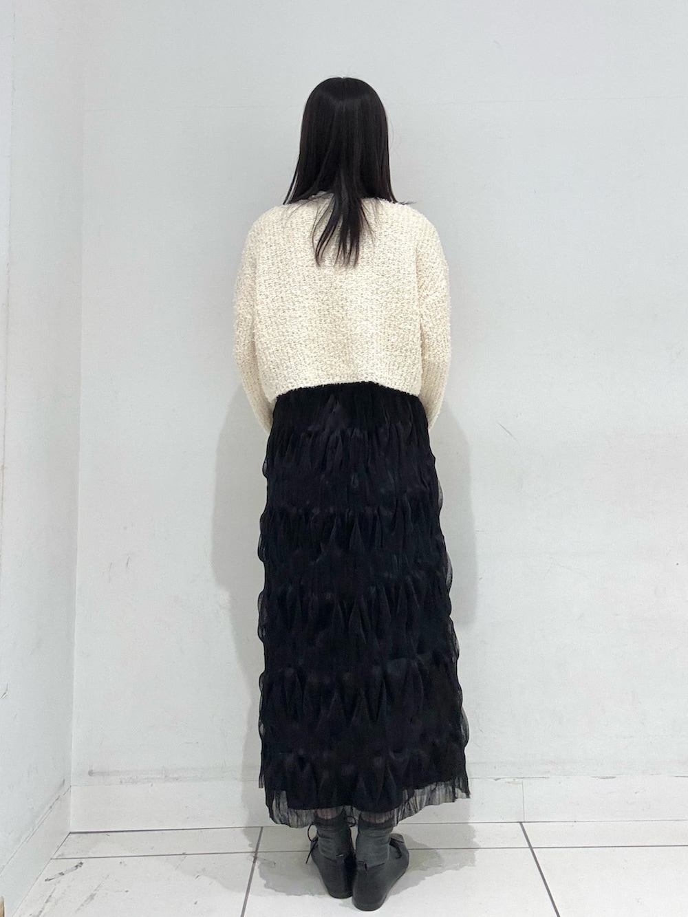 ホワイト系のTシャツ/カットソー、ホワイト系のカーディガン/ボレロ、ブラック系のスカートを着用したレディースの冬コーディネートの3枚目の写真