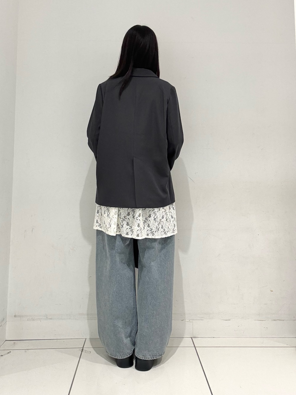 ホワイト系のキャミソール、ブルー系のデニムパンツ、ブラック系のその他シューズを着用したレディースの冬コーディネートの3枚目の写真