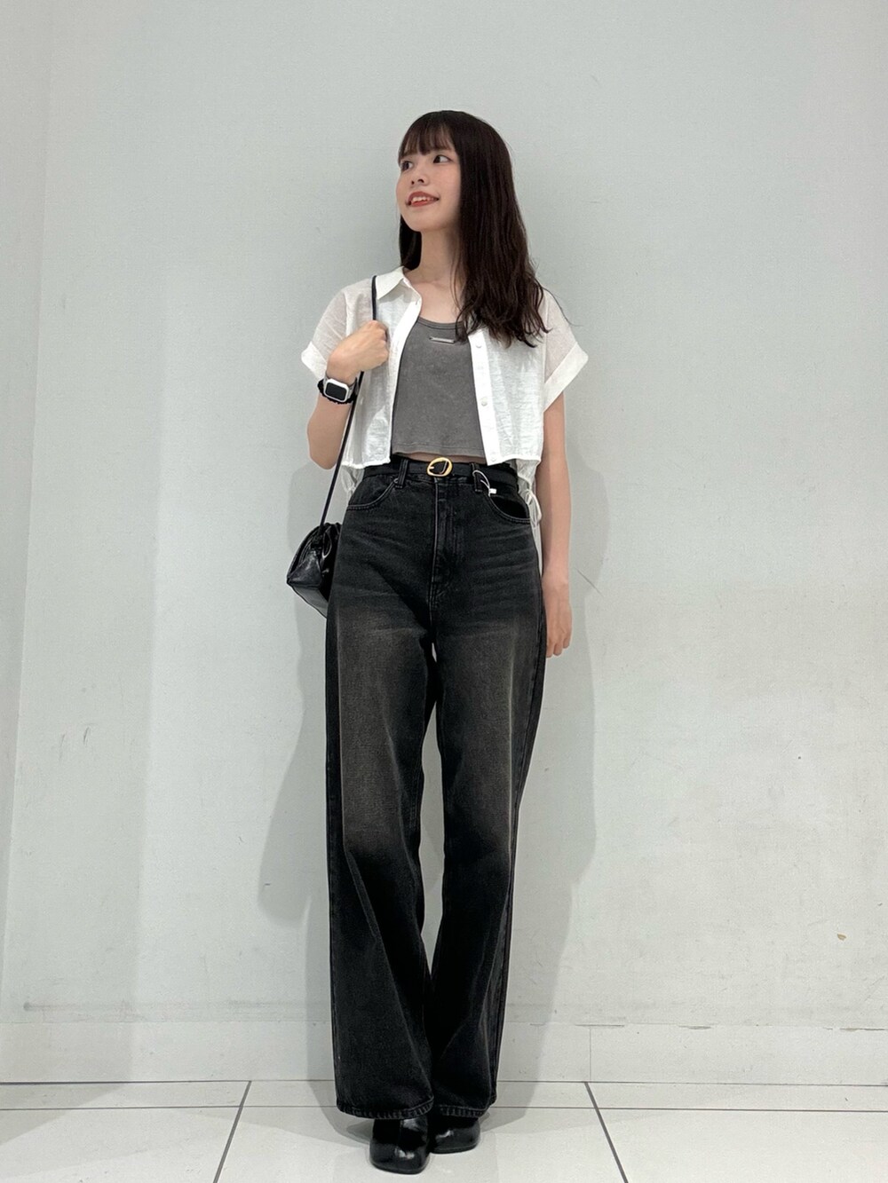 グレー系のタンクトップ、ブラック系のデニムパンツ、ブラック系のサンダルを着用したレディースの秋コーディネートの2枚目の写真