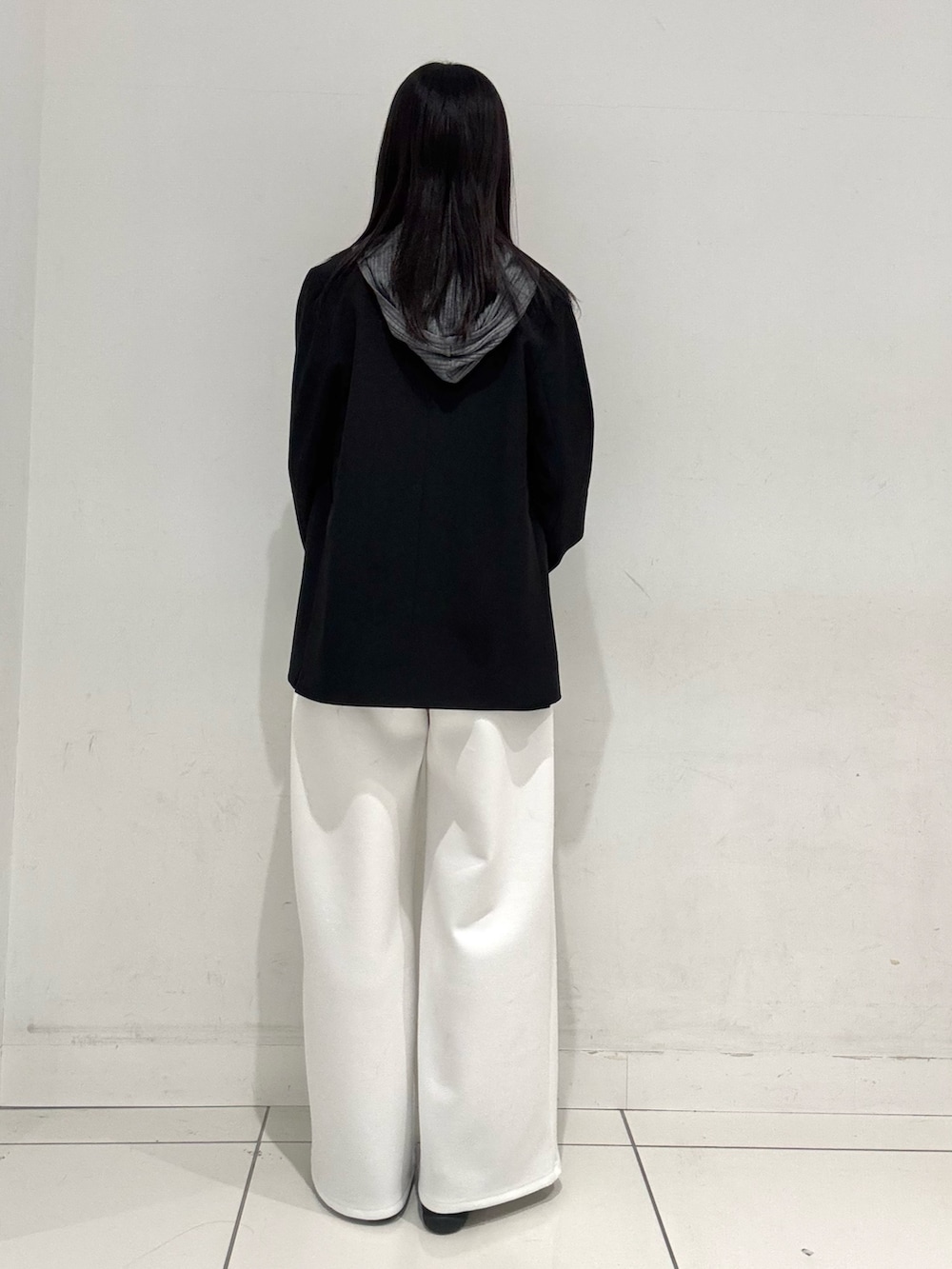 ブラック系のテーラードジャケット、グレー系のニット/セーター、ホワイト系のその他パンツを着用したレディースの春コーディネートの3枚目の写真