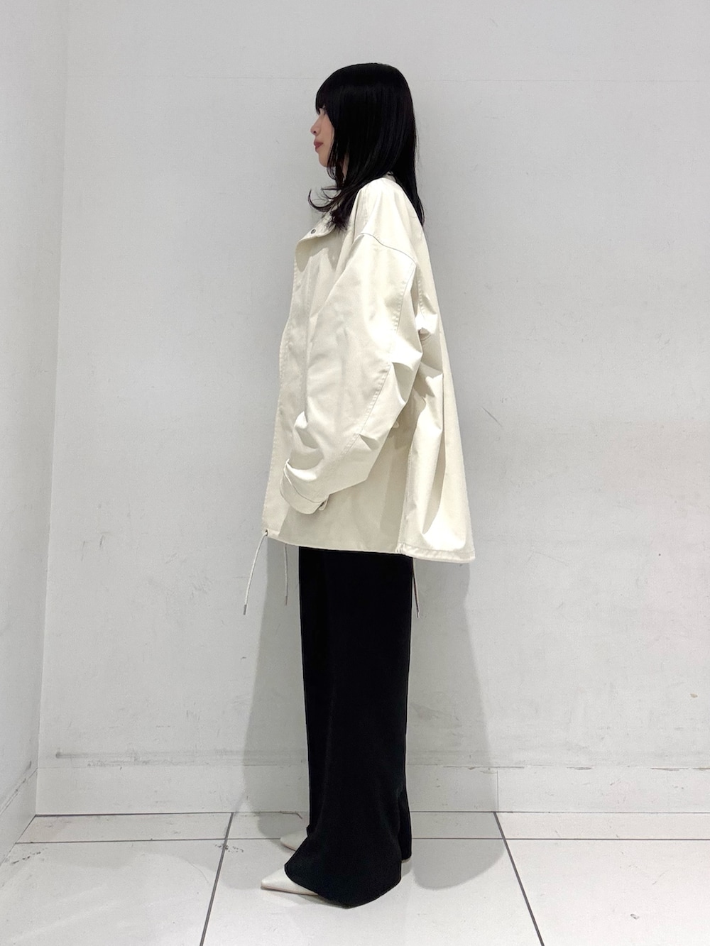 ホワイト系のシャツ/ブラウス、ホワイト系のミリタリージャケット、ブラック系のスラックスを着用したレディースの春コーディネートの2枚目の写真