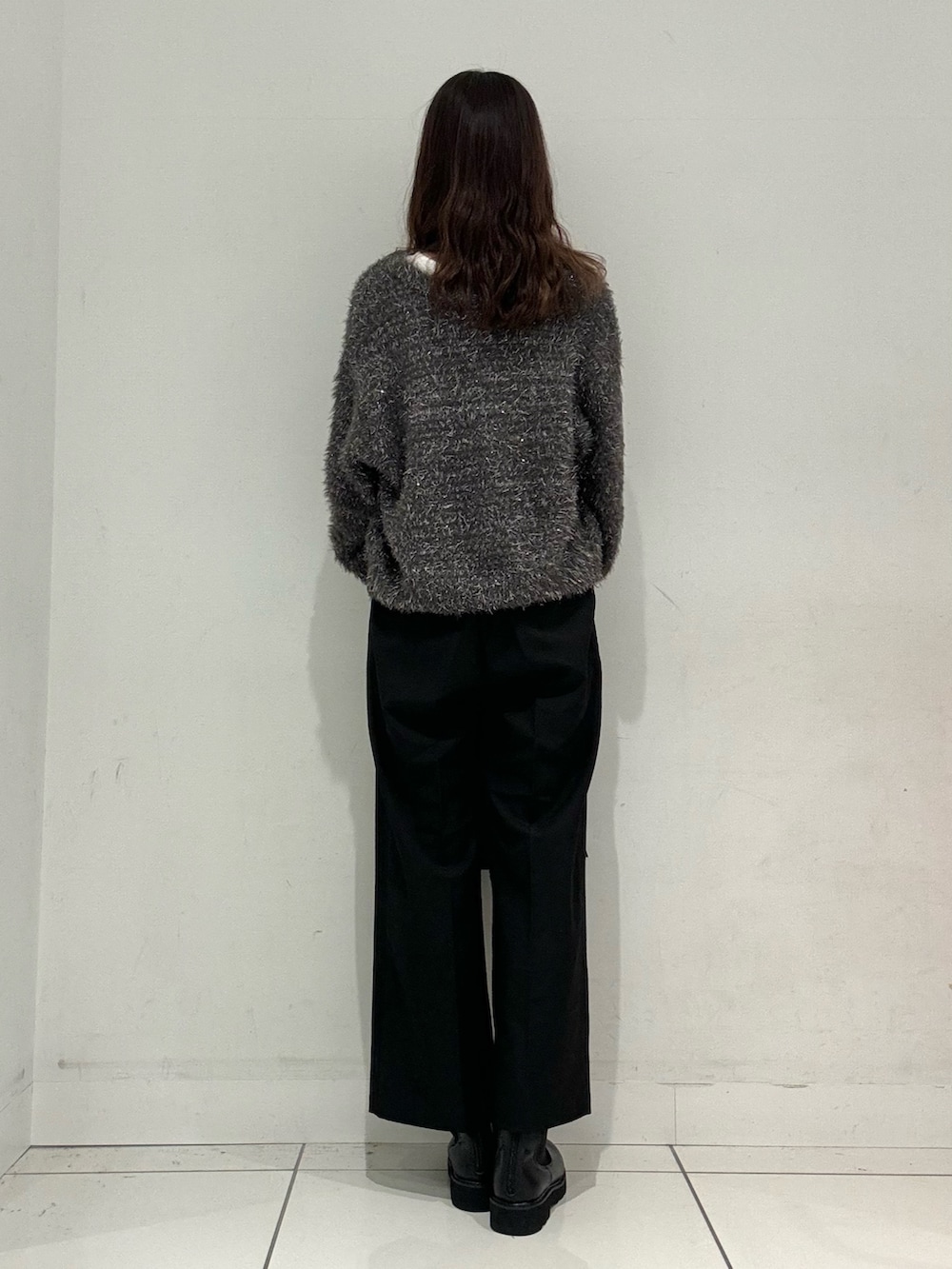 ホワイト系のTシャツ/カットソー、グレー系のニット/セーター、ブラック系のその他パンツを着用したレディースの秋コーディネートの3枚目の写真