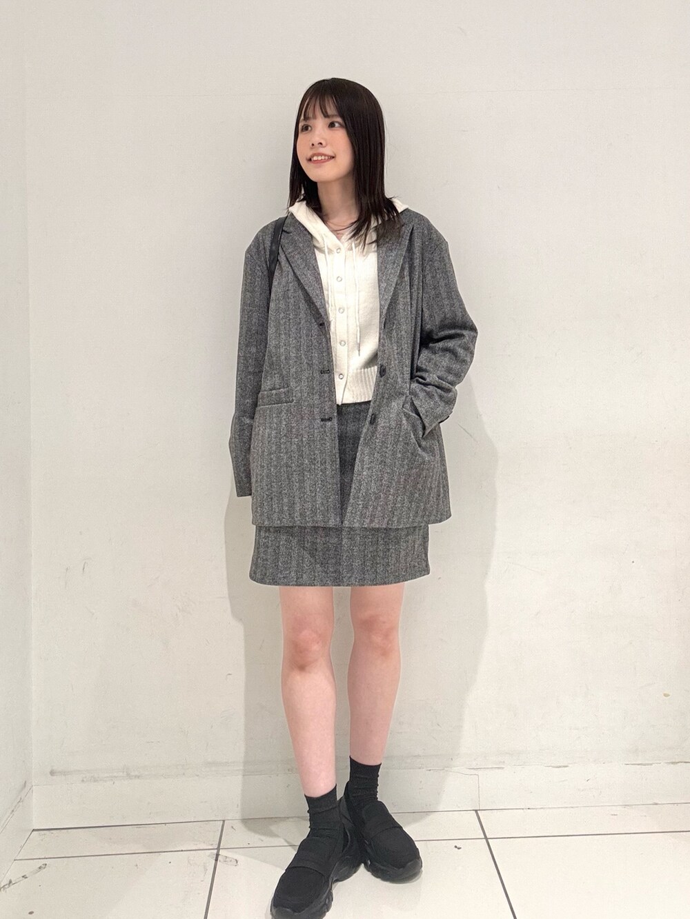 ブラック系のローファー、ホワイト系のニット/セーター、ブラック系のその他アウターを着用したレディースの秋コーディネートの4枚目の写真