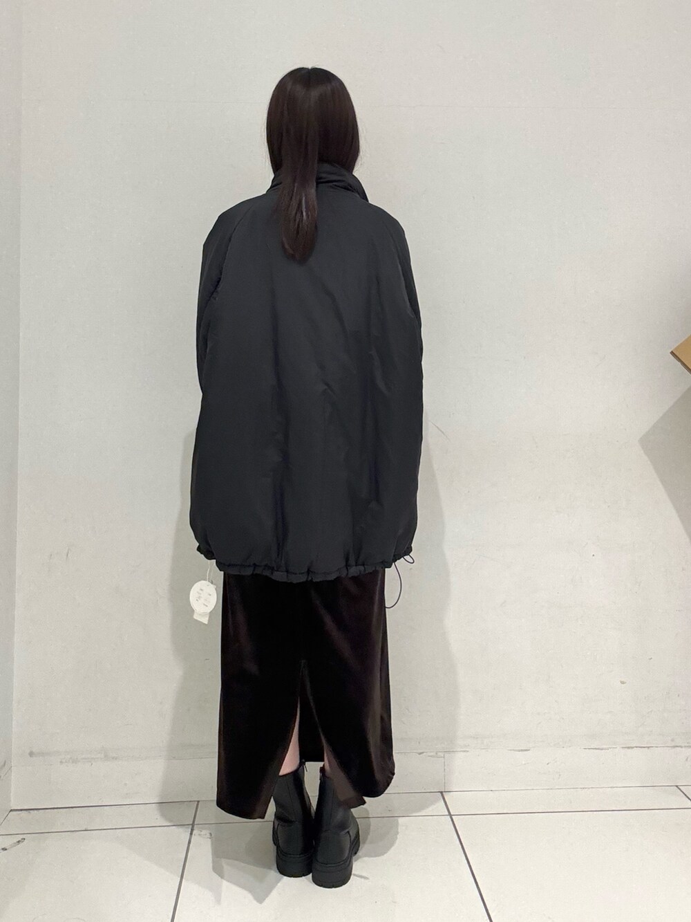 ブルー系のカーディガン/ボレロ、ブラック系のダウンジャケット/コート、ブラウン系のスカートを着用したレディースの冬コーディネートの3枚目の写真