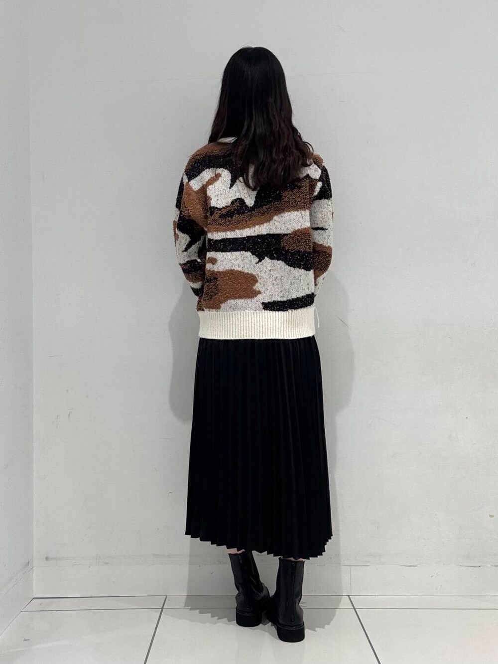 ホワイト系のニット/セーター、ブラック系のブーツ、ブラック系のハンドバッグを着用したレディースの冬コーディネートの3枚目の写真