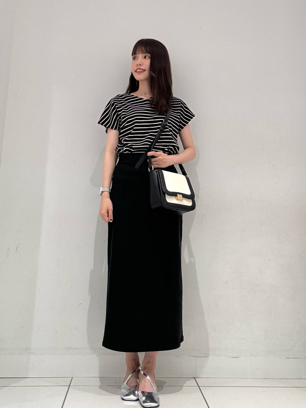 ブラック系のTシャツ/カットソー、ブラック系のショルダーバッグ、ブラック系のスカートを着用したレディースの夏コーディネートの4枚目の写真