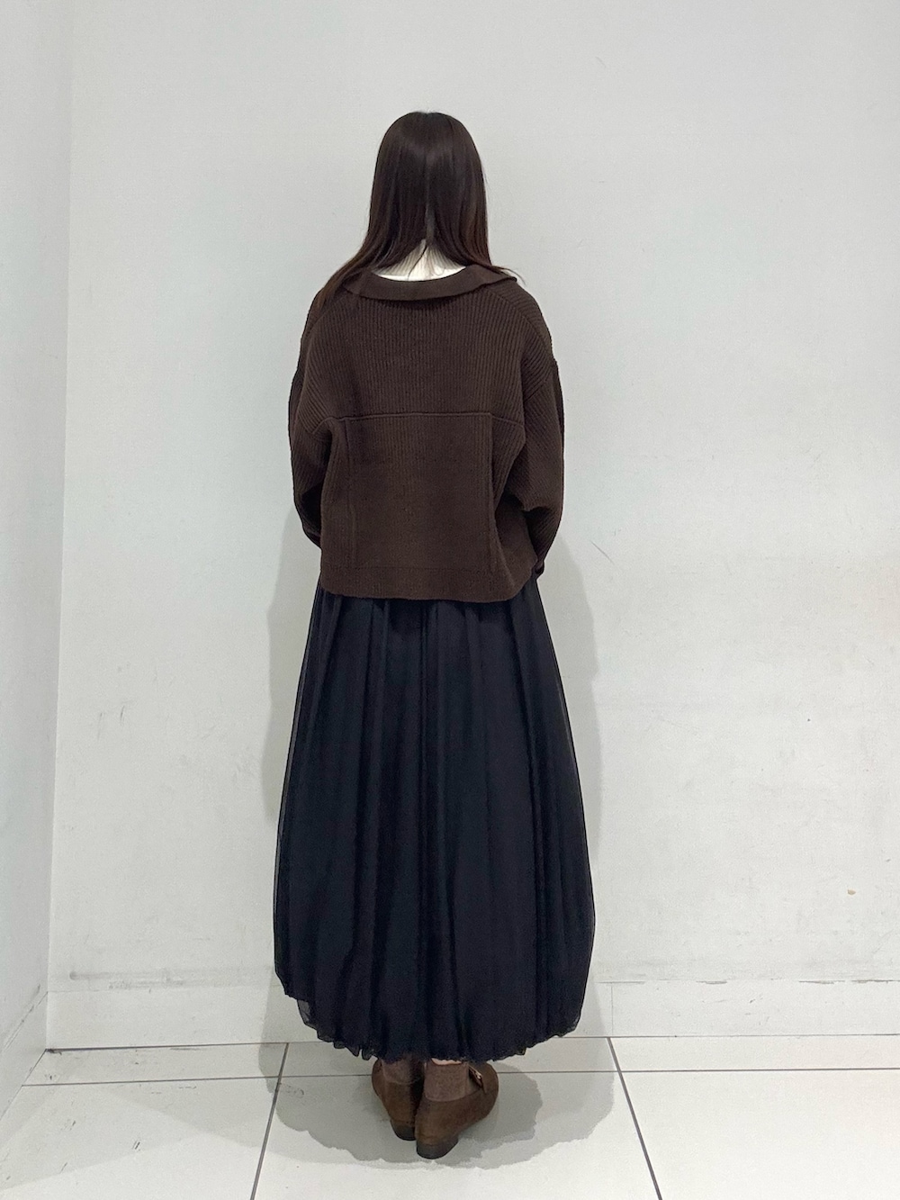 ホワイト系のニット/セーター、ブラウン系のその他アウター、ブラック系のスカートを着用したレディースの秋コーディネートの3枚目の写真