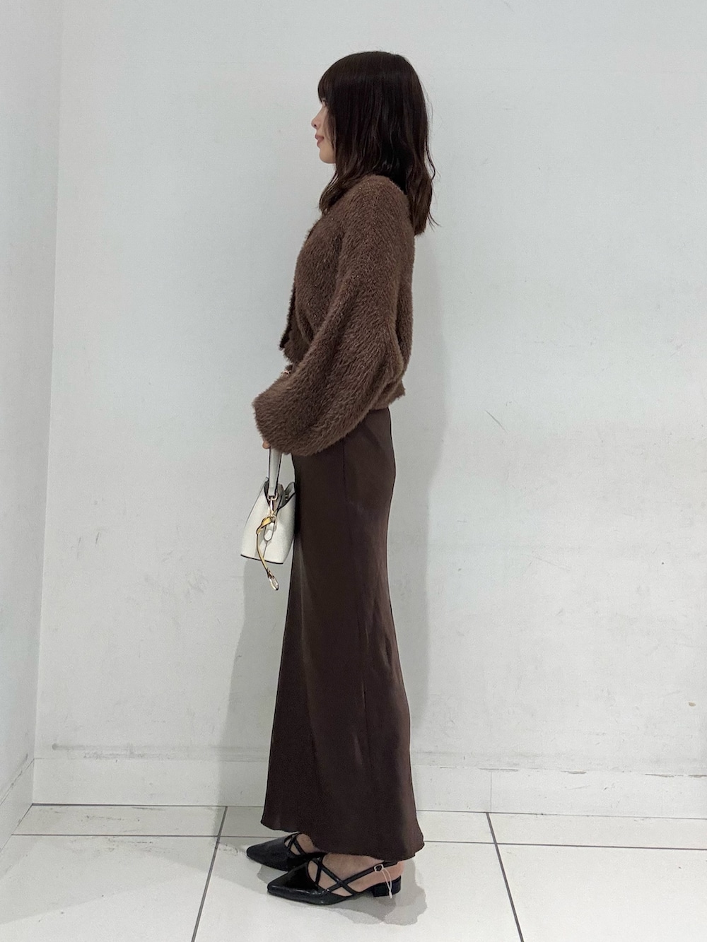 ブラウン系のスカート、ブラウン系のカーディガン/ボレロ、ブラック系のその他シューズを着用したレディースの秋コーディネートの2枚目の写真