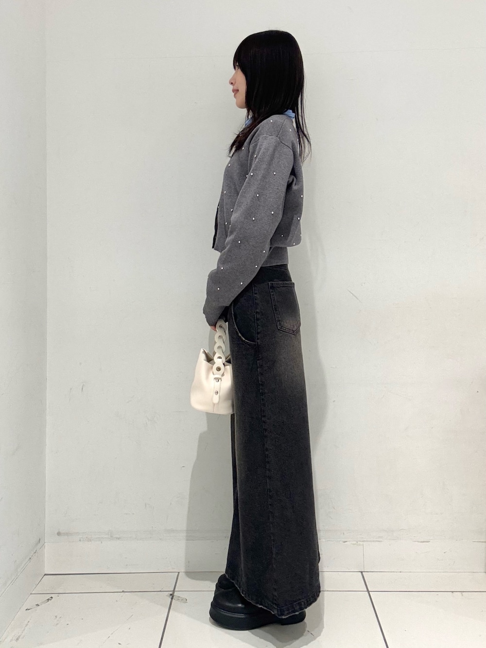 ブラック系のスカート、ブラック系のその他シューズ、ホワイト系のショルダーバッグを着用したレディースの冬コーディネートの2枚目の写真