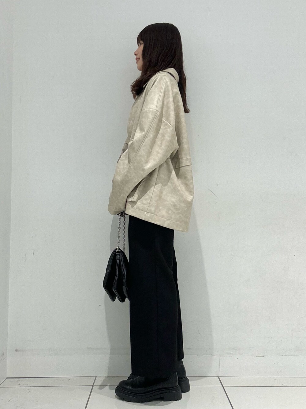 オレンジ系のニット/セーター、ホワイト系のその他アウター、ブラック系のその他パンツを着用したレディースの秋コーディネートの2枚目の写真