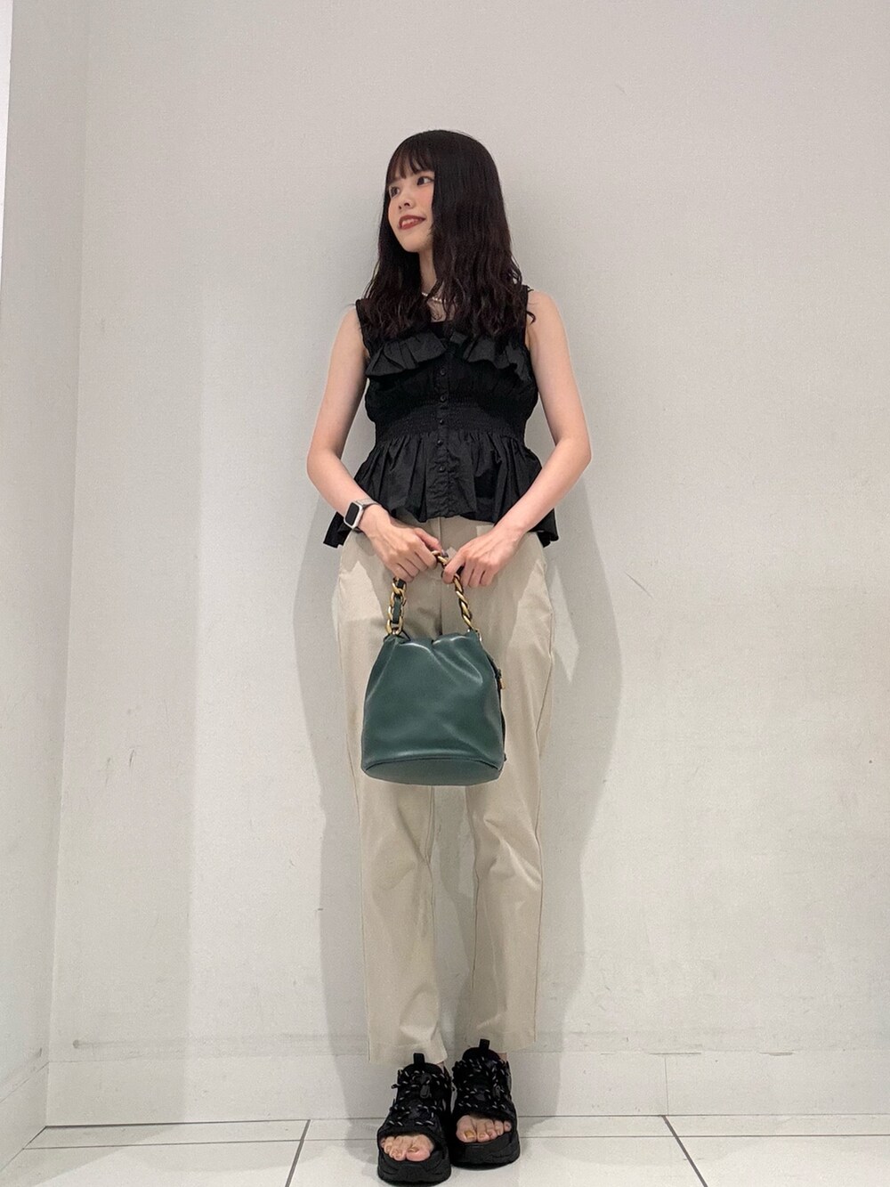 ベージュ系のその他パンツ、ブラック系のキャミソール、グリーン系のショルダーバッグを着用したレディースの夏コーディネートの2枚目の写真