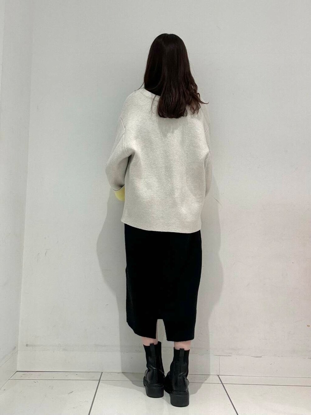 ベージュ系のハンドバッグ、ベージュ系のその他アウター、ブラック系のワンピースを着用したレディースの秋コーディネートの2枚目の写真