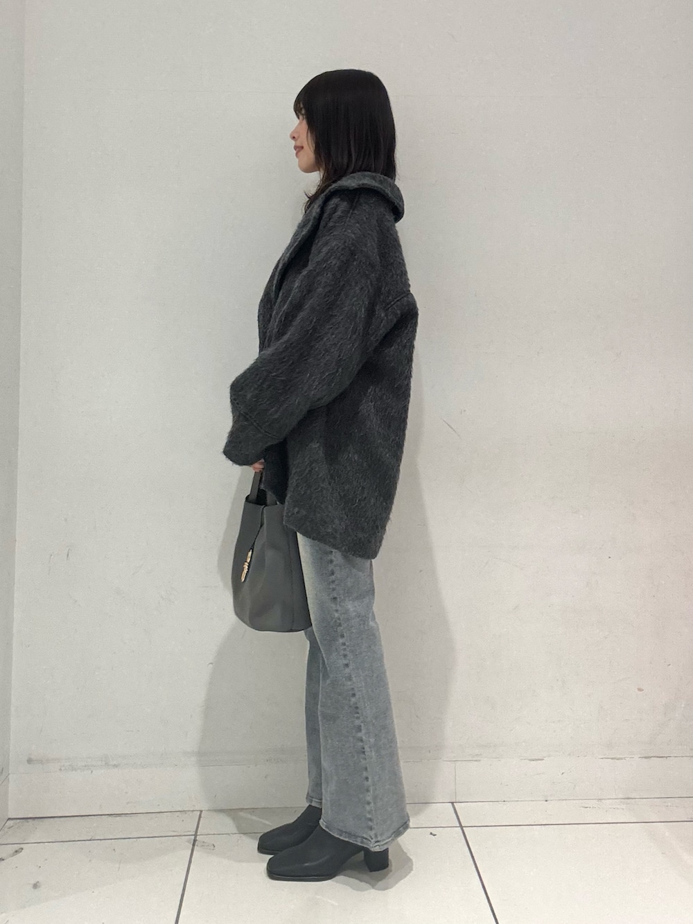 グレー系のその他アウター、レッド系のニット/セーター、ブルー系のその他パンツを着用したレディースの秋コーディネートの2枚目の写真