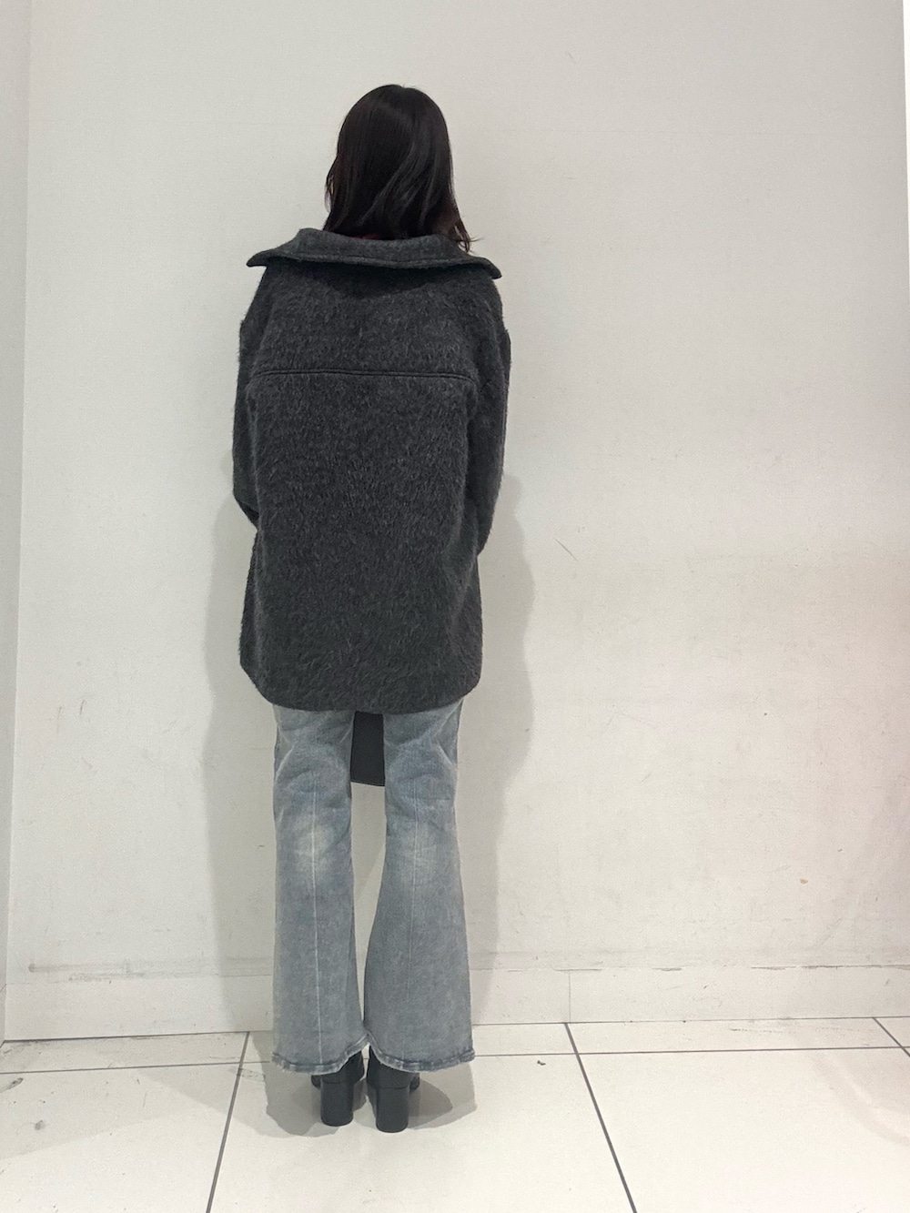 グレー系のその他アウター、レッド系のニット/セーター、ブルー系のその他パンツを着用したレディースの秋コーディネートの3枚目の写真