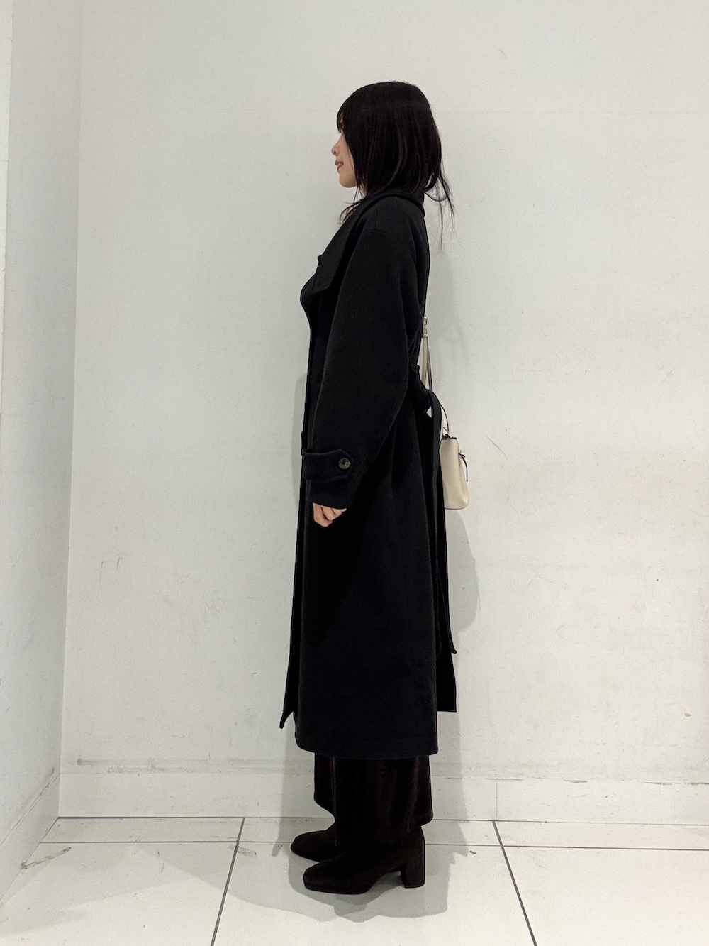 ホワイト系のニット/セーター、ブラウン系のスカート、ブラウン系のブーツを着用したレディースの秋コーディネートの2枚目の写真