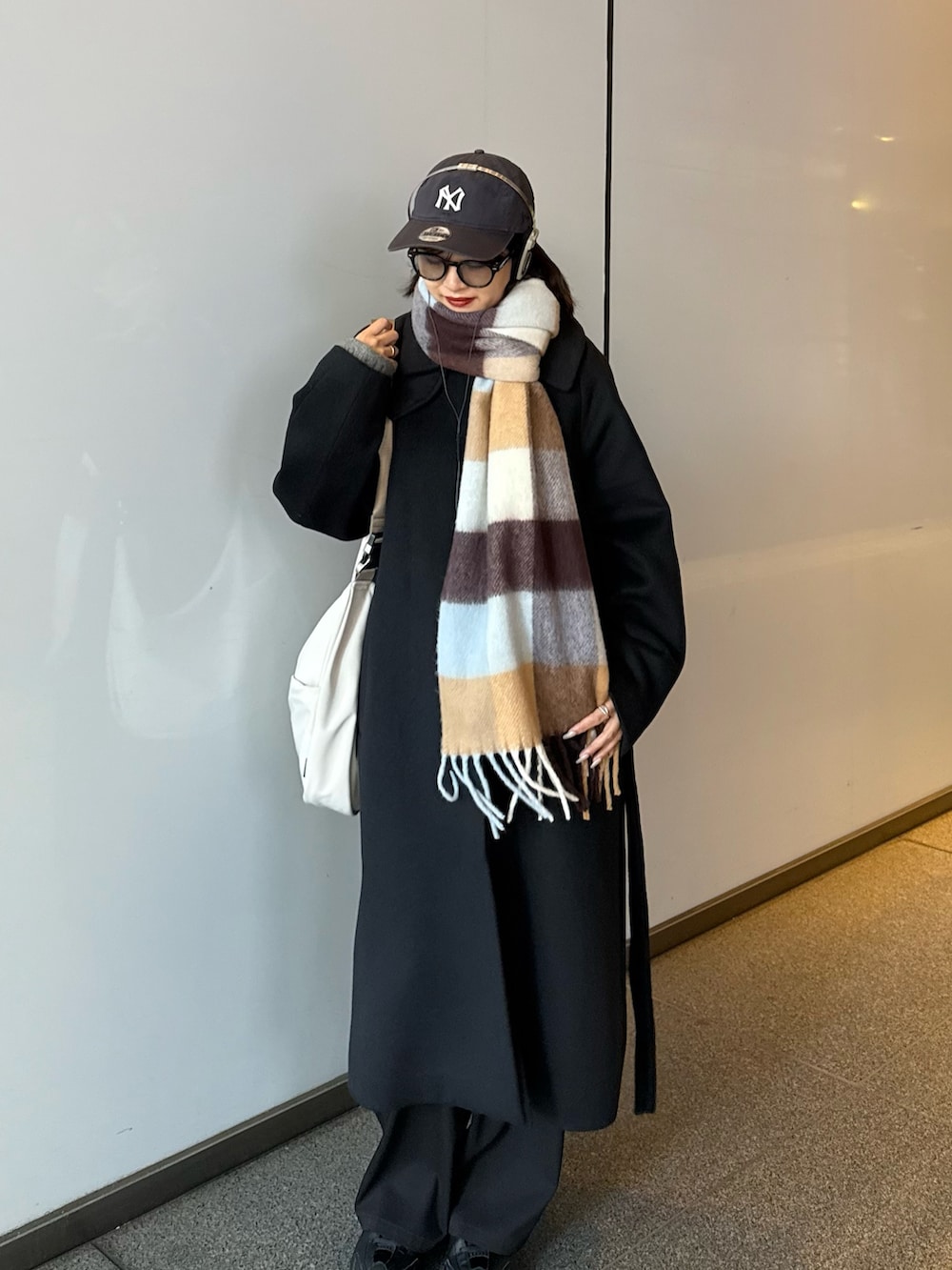 ブラック系のチェスターコート、ブラック系のその他アウター、ブラウン系のマフラーを着用したレディースの秋コーディネートの3枚目の写真