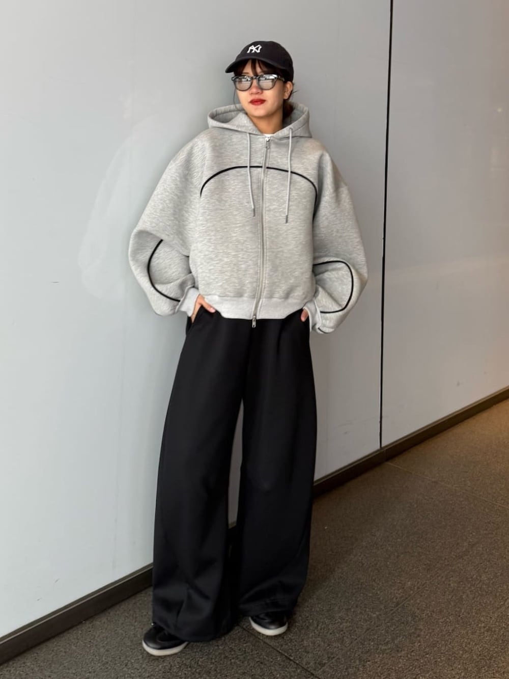 グレー系のパーカー、グレー系のその他パンツ、ブラック系のサングラスを着用したレディースの春コーディネートの4枚目の写真