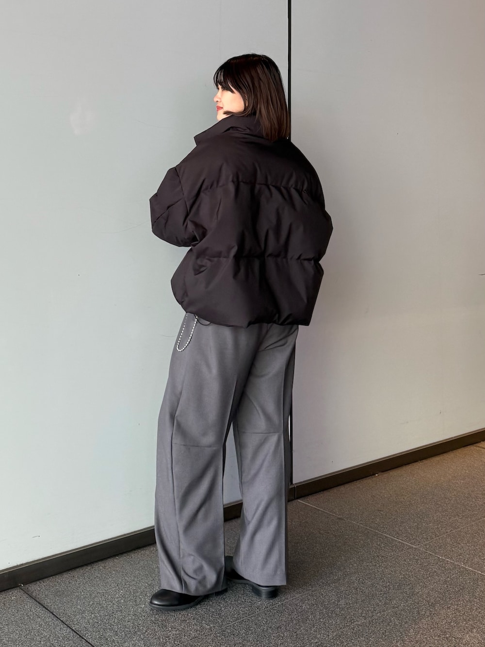 ホワイト系のダウンジャケット/コート、グレー系のスラックス、ブラック系のTシャツ/カットソーを着用したレディースの秋コーディネートの5枚目の写真