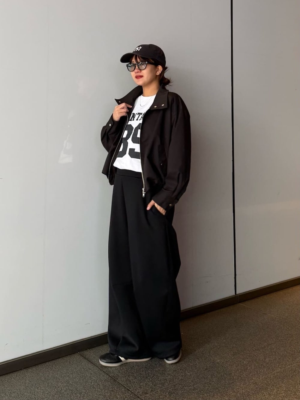 ブラック系のブルゾン、グレー系のその他パンツ、ブラック系のサングラスを着用したレディースの春コーディネートの2枚目の写真