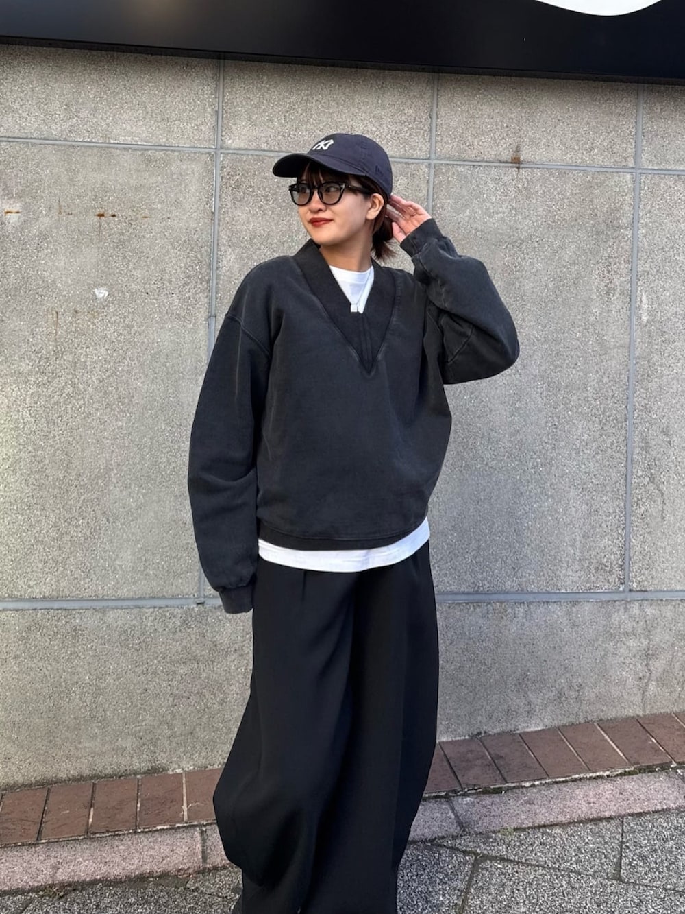 ブラック系のスウェット、ブラック系のスラックス、ブラック系のサングラスを着用したレディースの冬コーディネートの6枚目の写真