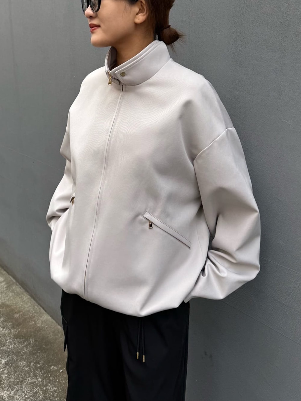 グレー系のブルゾン、ホワイト系のカーゴパンツを着用したレディースの冬コーディネートの6枚目の写真