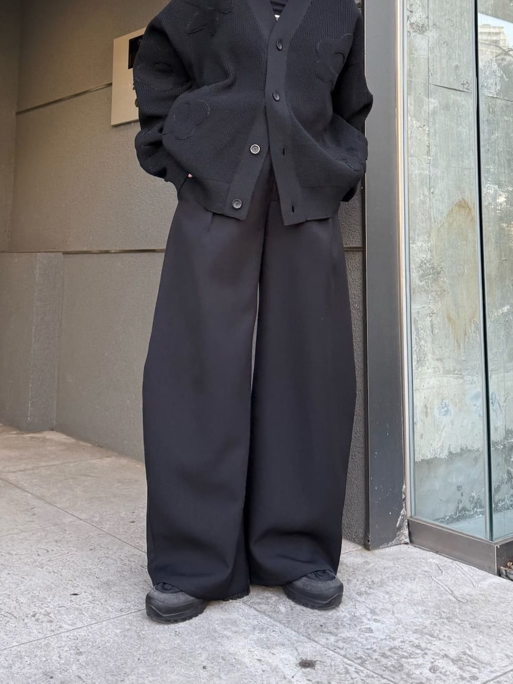 ブラック系のスラックス、ブラック系のカーディガン/ボレロ、ブラック系のサングラスを着用したレディースの冬コーディネートの5枚目の写真