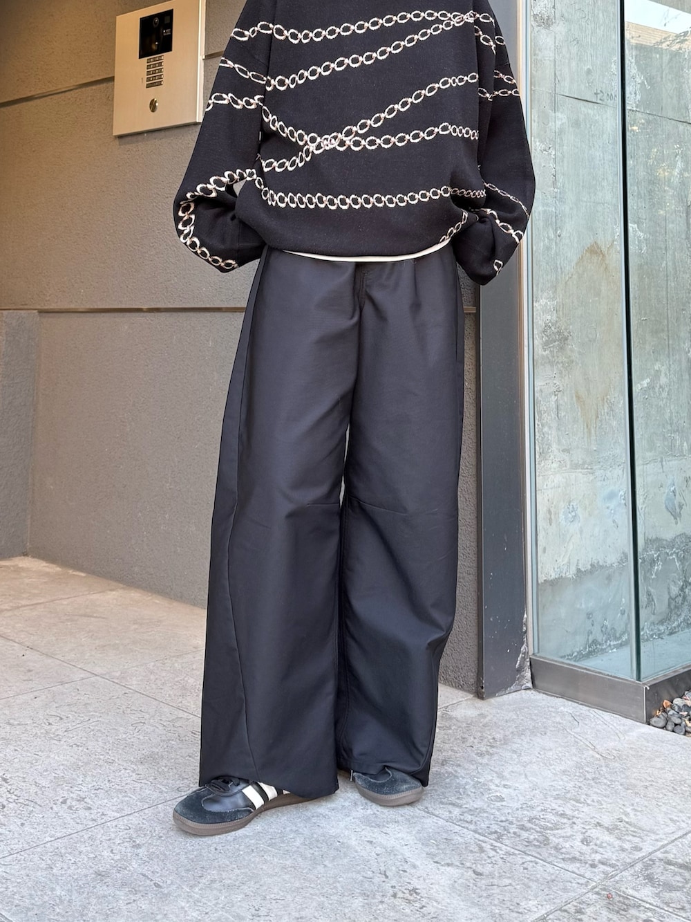 ブラック系のスラックス、ブラック系のニット/セーター、ブラック系のサングラスを着用したレディースの冬コーディネートの9枚目の写真