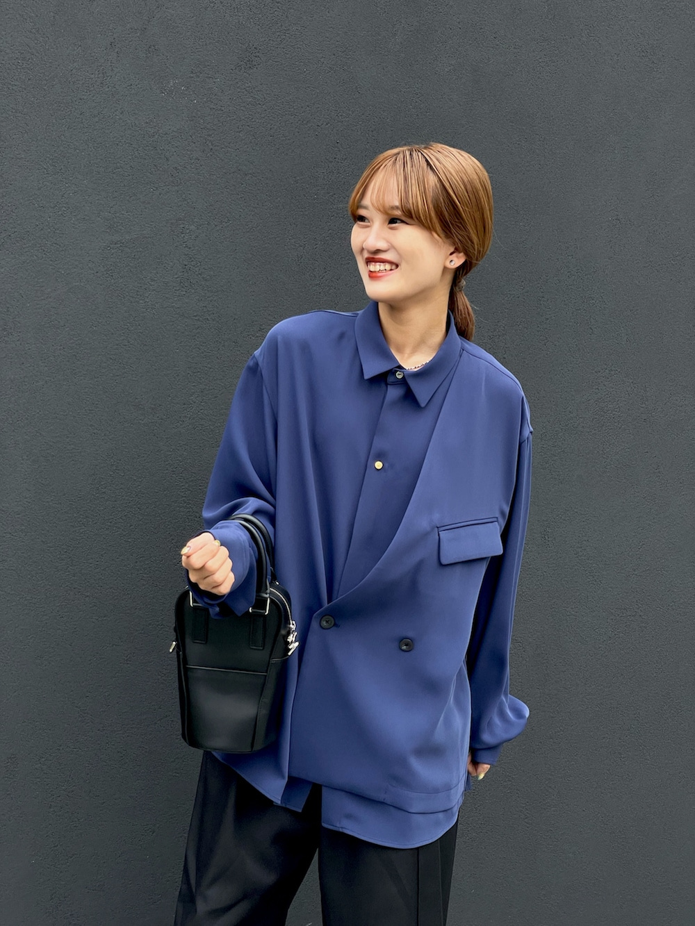 ブルー系のシャツ/ブラウス、ブラック系のショルダーバッグ、ブラック系のスラックスを着用したレディースの夏コーディネートの4枚目の写真