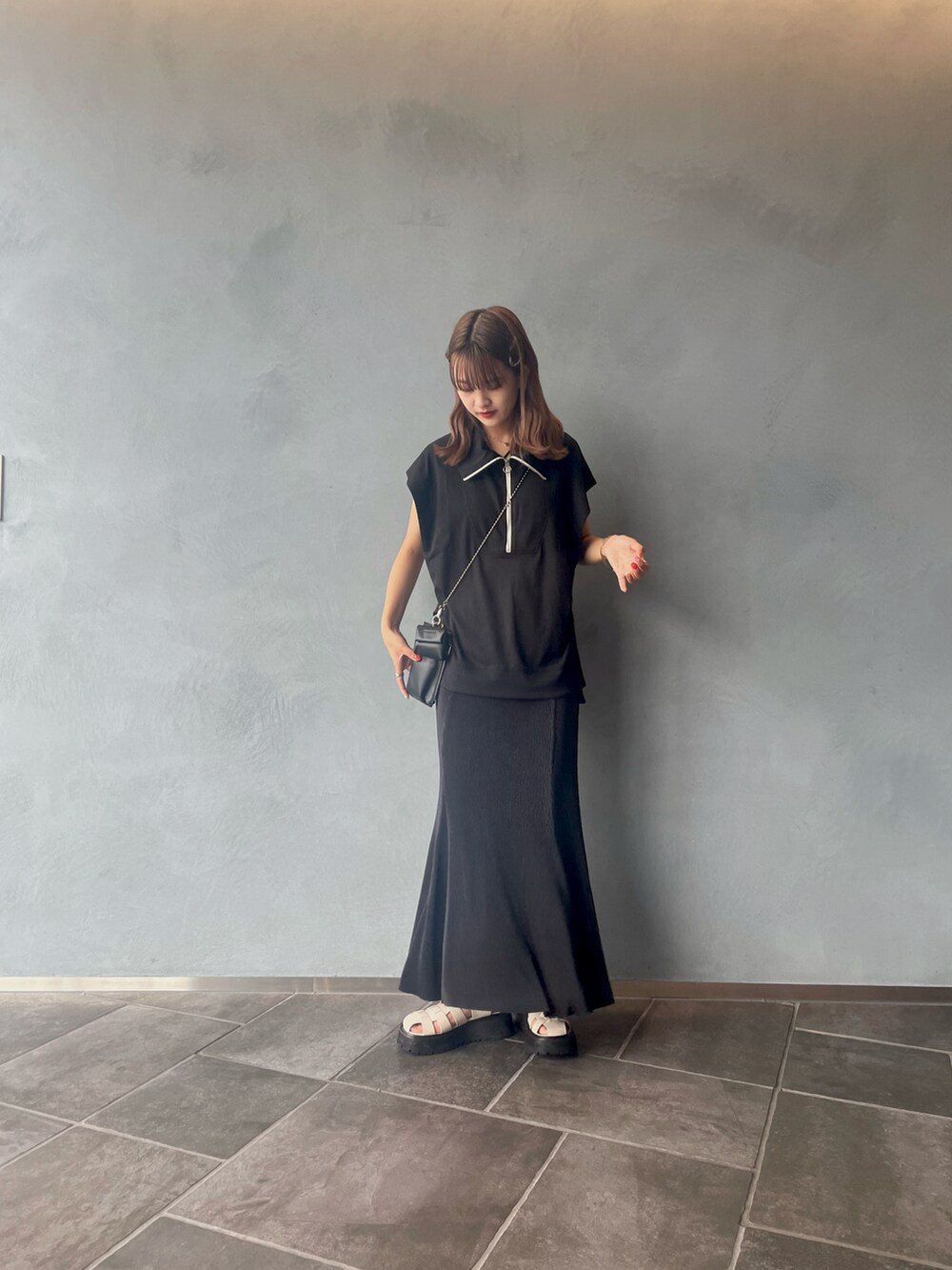 ブラック系のスカート、ブラック系のTシャツ/カットソーを着用したレディースの夏コーディネートの4枚目の写真