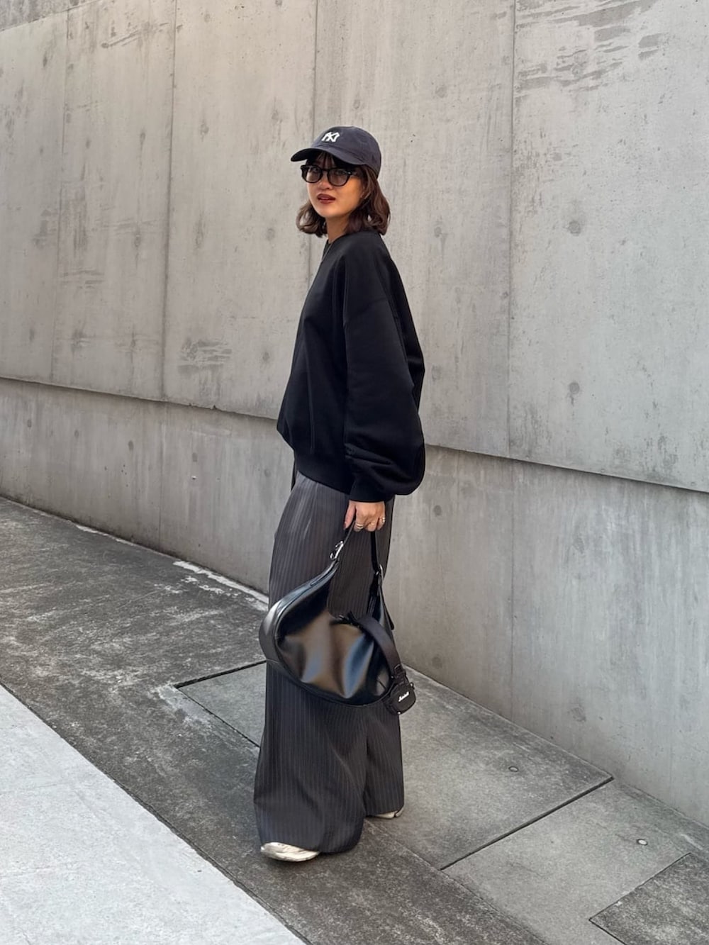 ホワイト系のスウェット、グレー系のスラックス、ブラック系のハンドバッグを着用したレディースの冬コーディネートの4枚目の写真