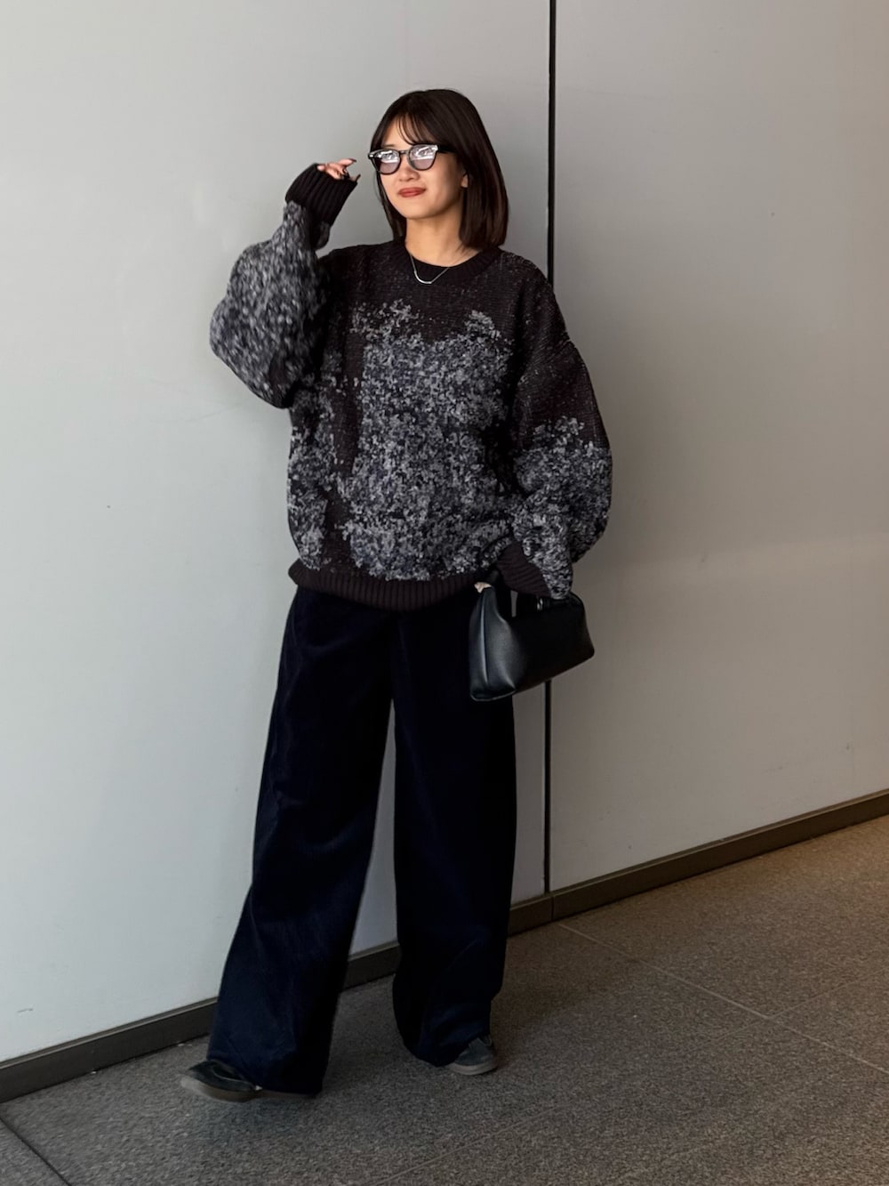 ブラック系のニット/セーター、ブラック系のトートバッグ、ブルー系のその他パンツを着用したレディースの秋コーディネートの4枚目の写真