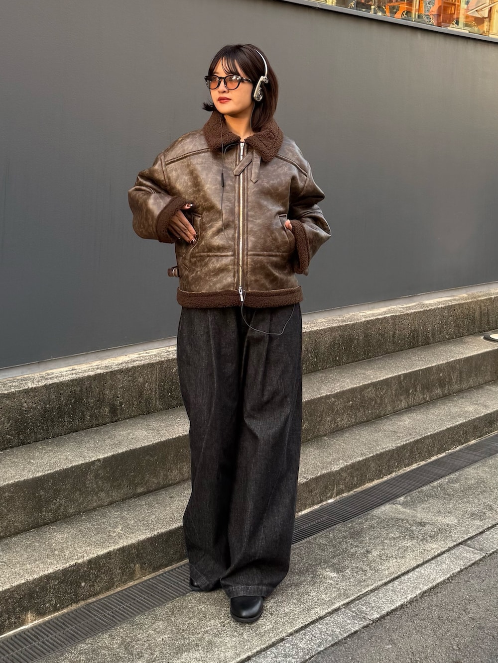 ブラウン系のブルゾン、ブラック系のデニムパンツを着用したレディースの秋コーディネートの3枚目の写真