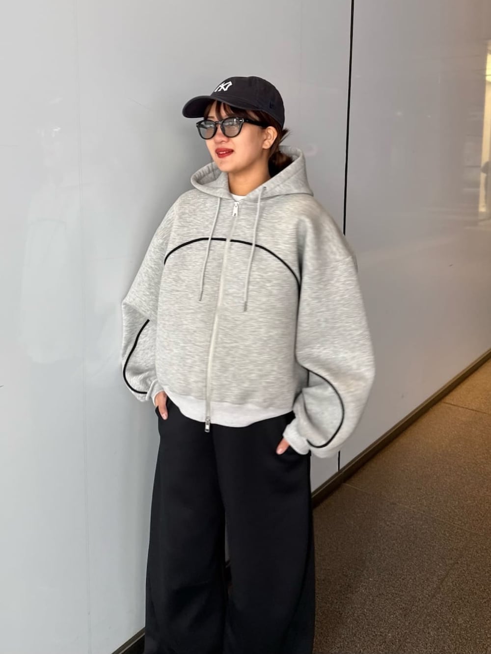 グレー系のパーカー、グレー系のその他パンツ、ブラック系のサングラスを着用したレディースの春コーディネートの2枚目の写真