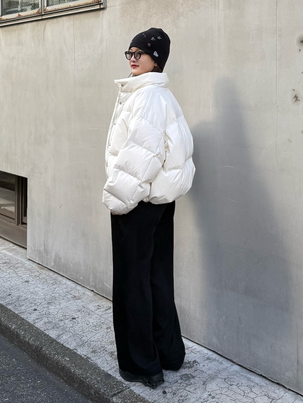 ホワイト系のダウンジャケット/コート、ブラック系のスラックス、ブラック系のベルトを着用したレディースの秋コーディネートの3枚目の写真