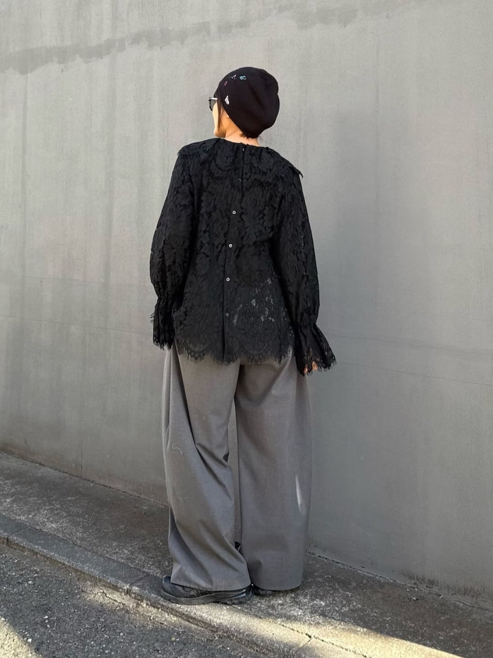 ブラック系のシャツ/ブラウス、グレー系のスラックスを着用したレディースの冬コーディネートの6枚目の写真