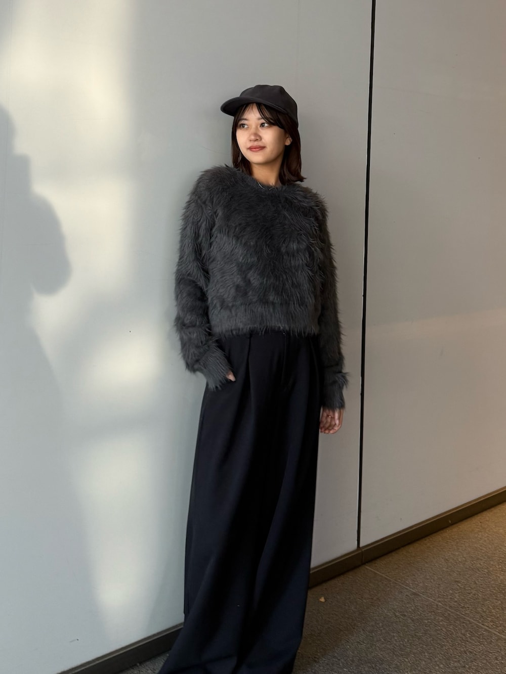 グレー系のニット/セーター、ブラック系のスラックスを着用したレディースの冬コーディネートの5枚目の写真