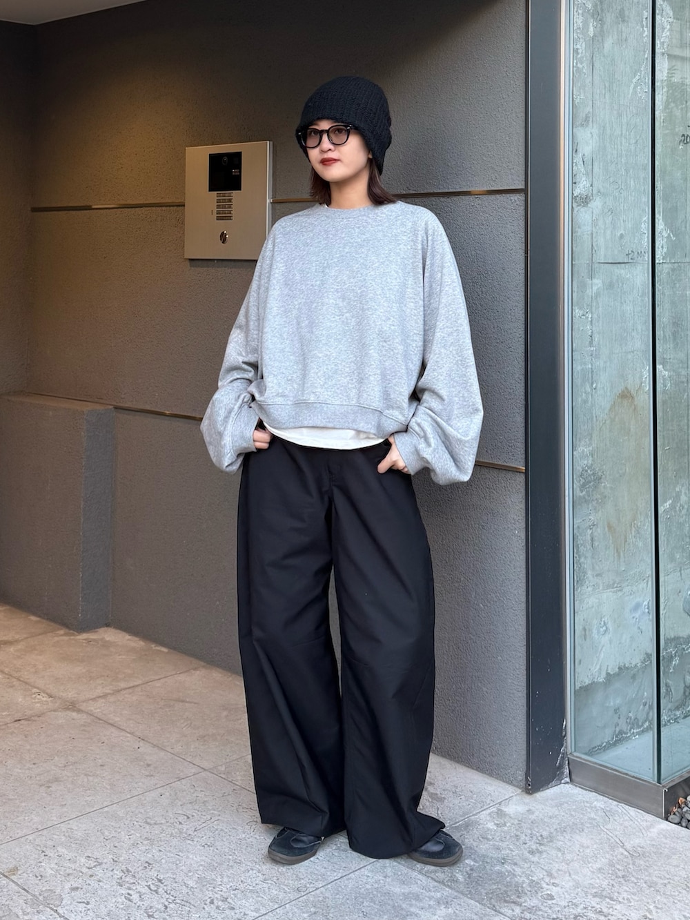 グレー系のスウェット、ブラック系のスラックス、ブラック系のサングラスを着用したレディースの冬コーディネートの5枚目の写真